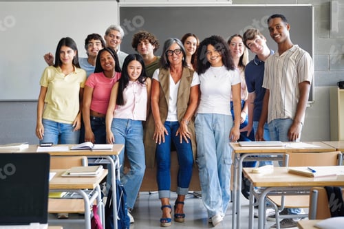 Preview: Group of teenager students with mature woman teacher at school classroom