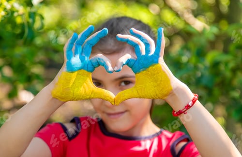 Preview: A child with the flag of Ukraine painted on his hands. Selective focus.