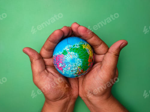 Preview: Hand holding earth globe on a green background