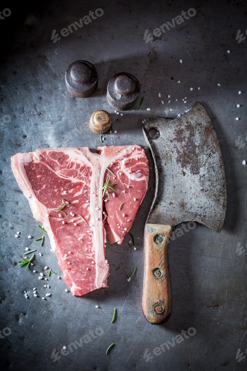 Preview: Bloody red steak with salt and rosemary on metal table