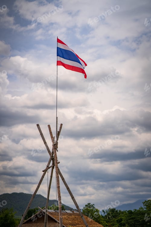 Preview: Vertical shot of waving Thai flag on pole against a cloudy sky