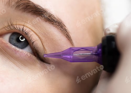 Preview: Micropigmentation Concept. Beautician doing permanent make up eyeliner procedure to young woman