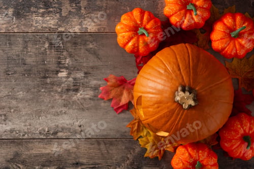 Preview: Halloween pumpkin and autumn leaves on wooden table