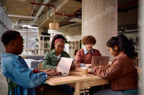 Preview: Multiracial group of university students using wireless technology while studying.