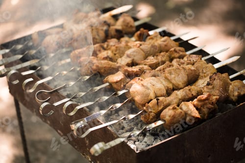 Preview: Marinated shashlik preparing on a barbecue grill over charcoal. Shashlik or Shish kebab popular in E
