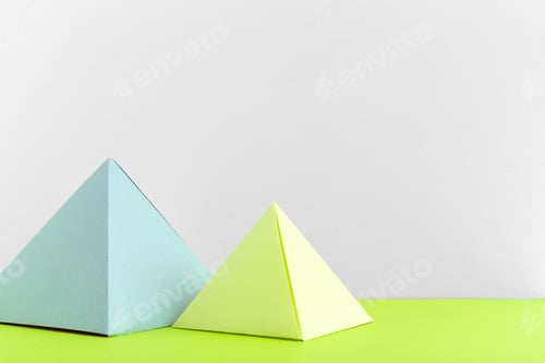 Preview: Colorful paper pyramids placed on a bright green surface against a white background