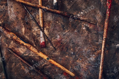 Preview: Dirty paintbrushes laying on the floor of an artist studio