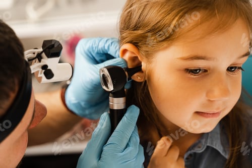 Preview: ENT doctor inspects child ear closely using otoscope