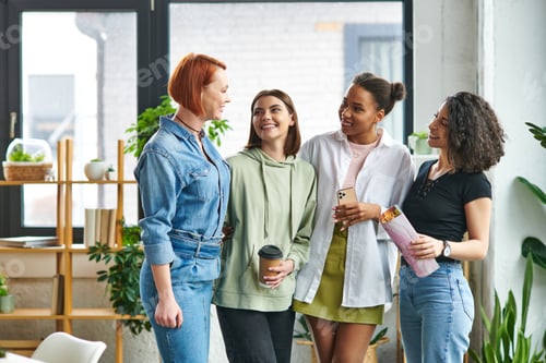 Preview: satisfied multiethnic girlfriends in stylish casual clothes, with coffee to go, magazine