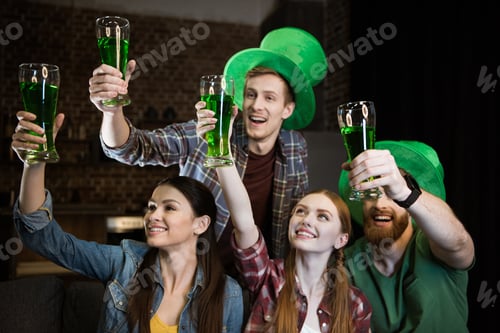 Preview: cheerful friends holding glasses with beer on St. Patrick's day celebration