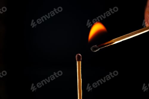 Preview: Side view of lighting one match to another one on dark background