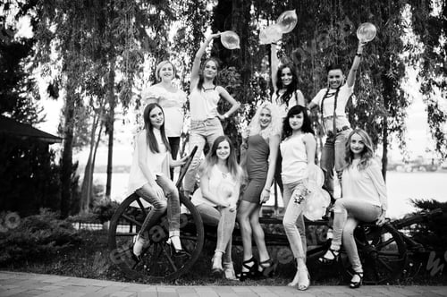 Preview: Comany of young women posing outside with inflated condoms at bachelorette party.