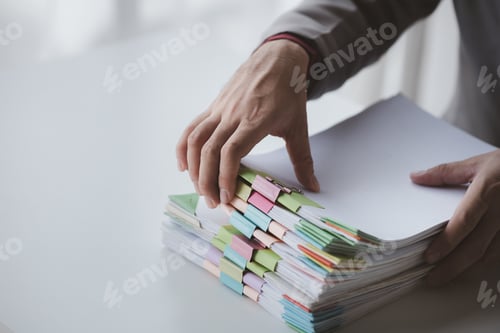 Preview: Person with stacks of company financial report papers in office, company employee picking up papers