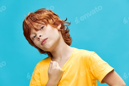 Preview: A boy with red hair in a yellow T-shirt leaned to the side against