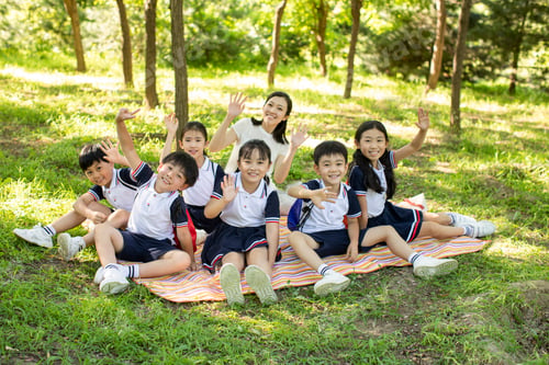 Preview: Cheerful Chinese school children picnicking outdoors with their teacher
