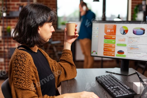 Preview: Businesswoman looking at computer screen analyzing management graphs