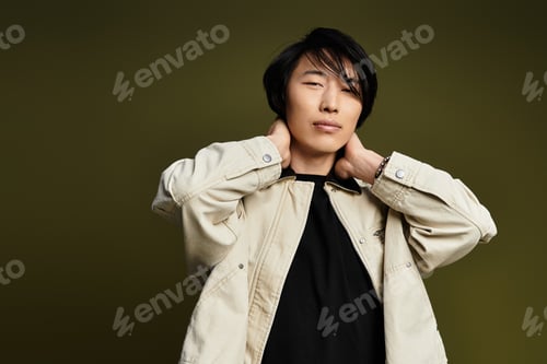 Preview: Stylish young man poses confidently in a modern studio setting with a unique backdrop