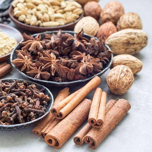 Preview: Different kinds of aromatic winter spices in bowls and on a gray concrete background, square