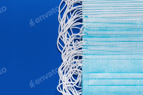Preview: Close-Up View of Lot Surgery and Medical Face Masks on Classic Blue Color Background