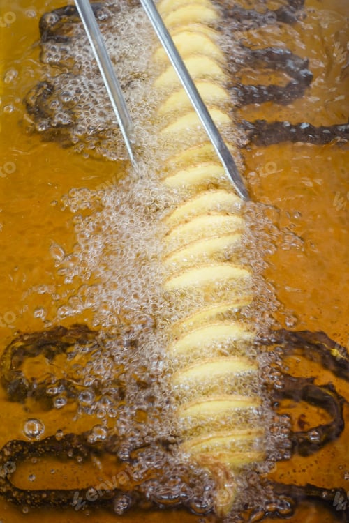 Preview: fried chips potatoes frying in boiling hot oil in a deep fryer,