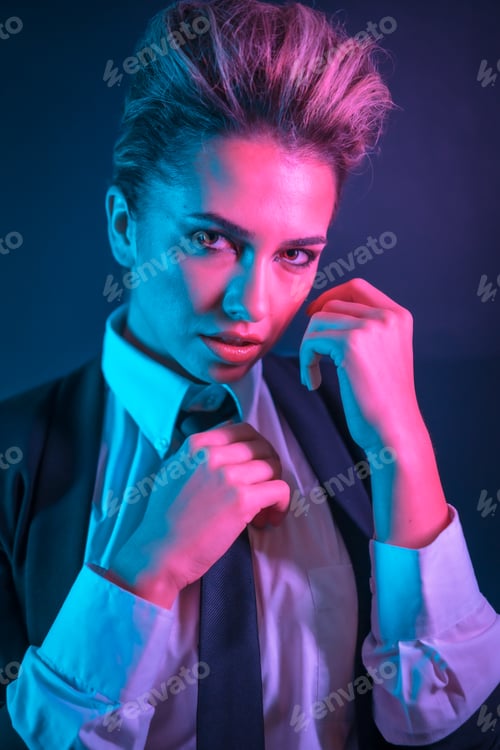Preview: A sexy young blonde hair female in a black suit posing in studio