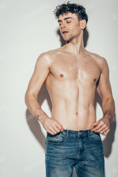 Preview: sexy shirtless stylish man in jeans posing on grey