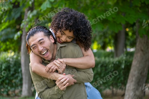 Visualização: Casal interracial se divertindo pegando carona no parque