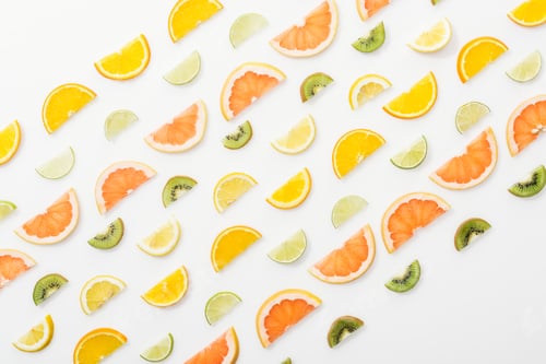 Preview: Flat lay with juicy cut fruits on white surface