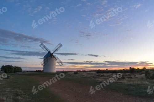 Preview: A scenic view of a traditional windmill against a colorful sunset sky in a rural landscape