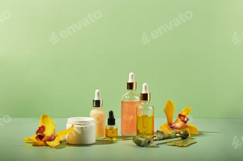 Preview: Cosmetic care products in glass bottles with orchid flowers - serums, cream, gel, oils. Concept for