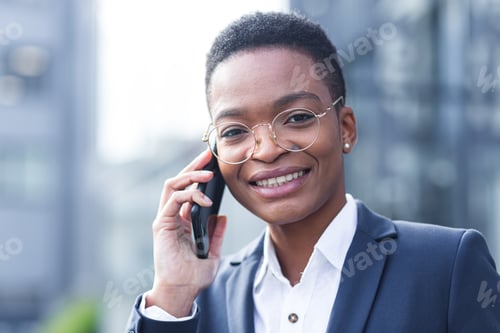 Preview: Close-up photo portrait of a young business woman, African American woman talking on the phone