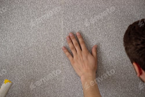 Preview: A man glues wallpaper, repairs the house.