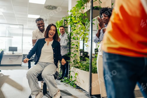 Preview: Asian woman and african american man participate in an office chair race