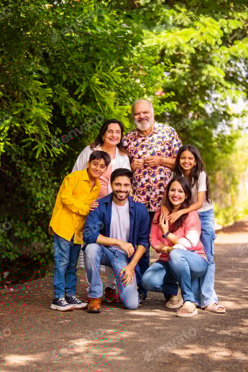 Preview: Indian family bonding happily while standing outdoors and smiling together
