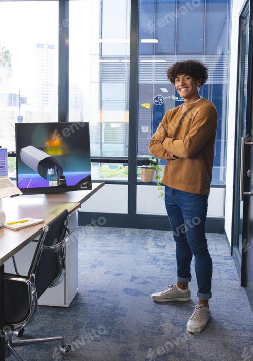 Preview: Smiling young man standing confidently in modern office near desk, copy space