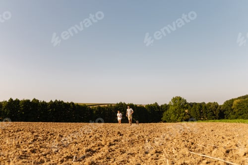 Preview: A man and his young son walk happily together in a bright, open field.