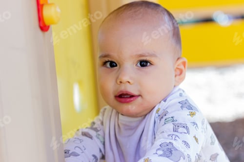 Preview: Cute little baby boy playing at children’s playground.