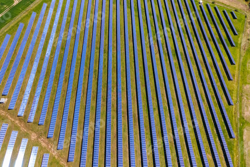 Preview: Aerial view of big sustainable electric power plant with many rows of solar photovoltaic panels for