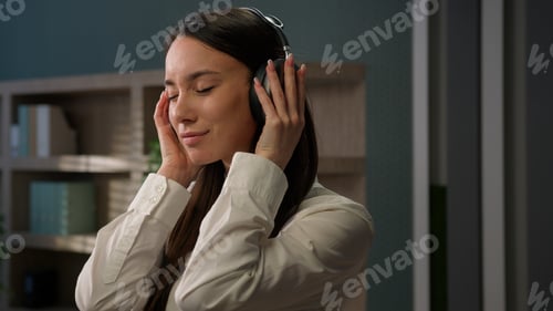 Preview: Relaxed Caucasian woman in workplace enjoying sound in wireless headphones close eyes inspired enjoy
