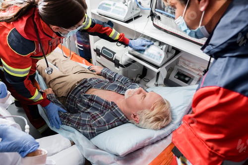 Preview: Selective focus of paramedics in medical masks and doctor standing near senior patient in ambulance