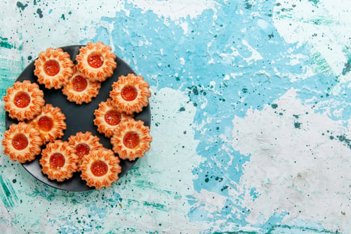 Preview: top view delicious cookies with jam inside black plate on blue background cookie biscuit sweet sugar