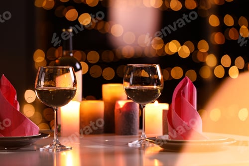 Preview: Romantic table setting with glasses of wine and burning candles against blurred background