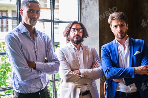 Preview: Three female co-workers standing in their office with their arms crossed and working together