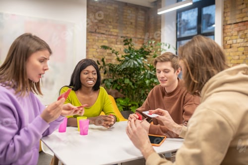 Preview: Friends sitting at the table and playing cards