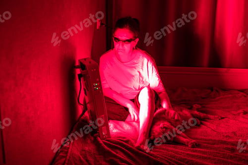 Preview: Senior Woman doing the Red Light Therapy Session with Panel and petting a cat