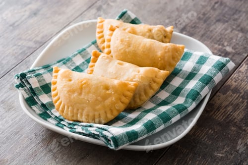Preview: Delicious empanadas resting on checkered cloth and plate