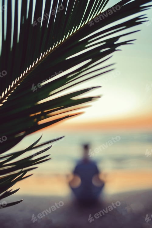 Preview: Silhouette of candid authentic millennial man sitting in lotus pose on tropical sea coast
