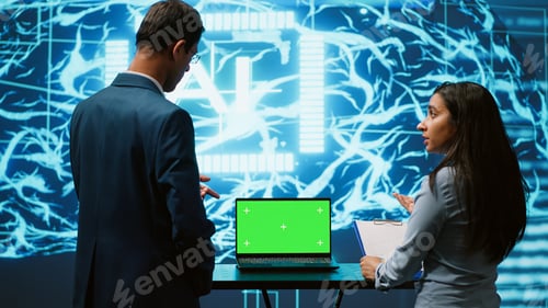 Preview: Startup coworkers looking over charts, using AI software on mockup laptop