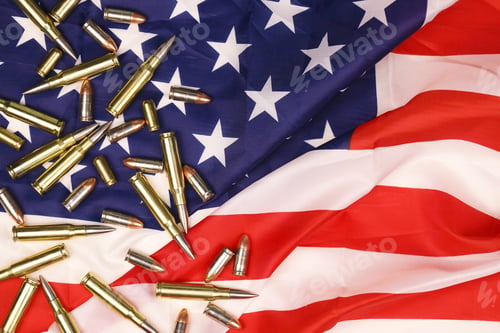 Preview: Many yellow 9mm and 5.56mm bullets and cartridges on United States flag
