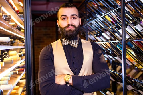 Preview: arabian man sommelier appreciating drink in lux hotel